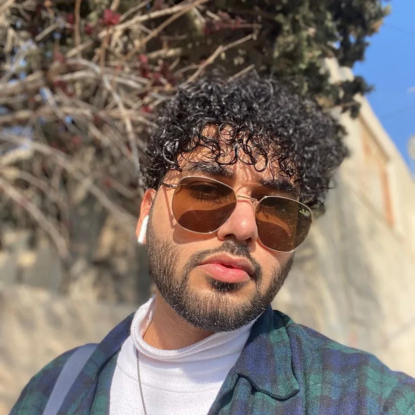 Nader Alzghoul in gold aviators, outdoors in the sun